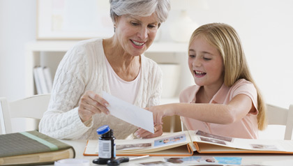 Grandmother and granddaughter working on scrap book at home