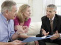 Couple sitting on a couch speaking with an investment advisor