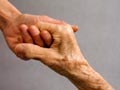 Younger hand clasping older hand