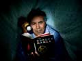 Mature man reading The Hunger Games in bed
