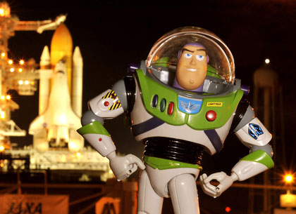 Toy Story 3: Buzz Lightyear (voz: Tim Allen) posando con un cohete espacial en el fondo