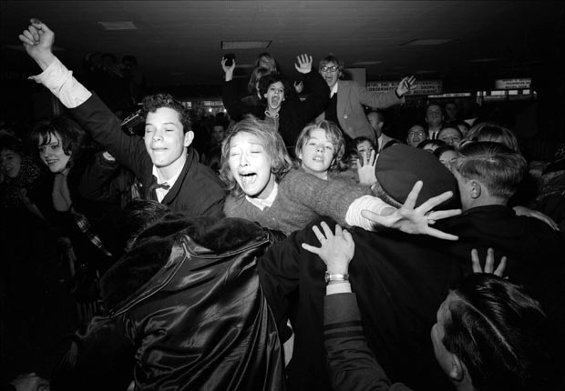 rock n roll enthusiasts rocked the conservative culture in America during the 1960s- beatles fans scream at kennedy airport