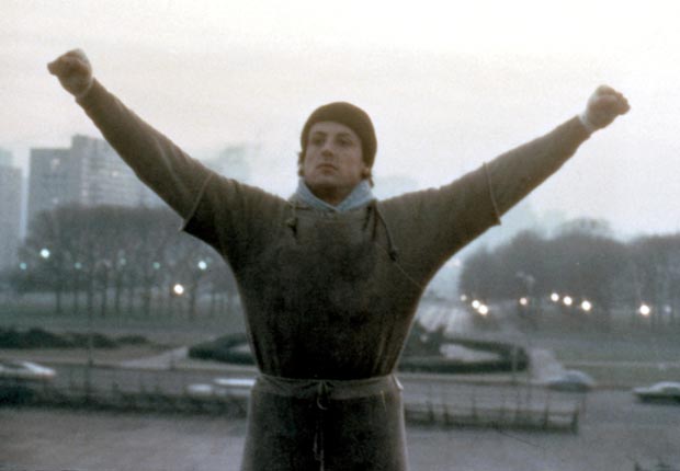Sylvester Stallone in 'Rocky' when the titular character raises his arms in victory as he trains for a boxing match that he subsequently loses.