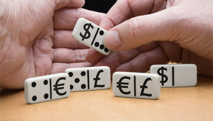 Unas manos organizan unas fichas de dominó con símbolos de dólar, euro y libra esterlina. Unas manos organizan unas fichas de dominó con símbolos de dólar, euro y libra esterlina.