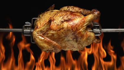 Rotisserie Chicken on Spit over Flames 	