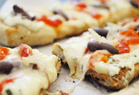 Grilled pizzas with ricotta, roasted peppers and olives.