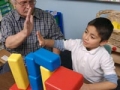 Man playing blocks with boy, AARP Experience Corps, News Release
