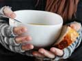 hands holding bread and a bowl of soup hands holding bread and a bowl of soup