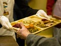 Volunteers hand out prepared hot food trays to homeless Volunteers hand out prepared hot food trays to homeless