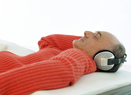 man in prone position with ear phones