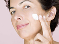 Woman applying cream to cheek. Which over the counter skin care products work best?