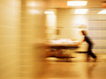 Nurse rushing a patient on a stretcher down a hallway. How to avoid hospital readmission.