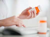 pharmacist looking at prescription drug bottles