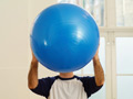 Mature man holding exercise ball in front of face