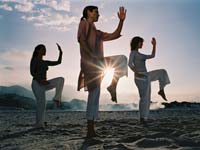 Friends Practicing Tai-Chi On Beach At Dawn Friends Practicing Tai-Chi On Beach At Dawn