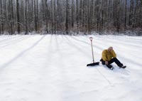 Man with snow shovel in wintery landscape-dangers of winter Man with snow shovel in wintery landscape-dangers of winter