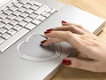 Woman using heart-shaped touchpad on laptop, How to stay safe when dating online