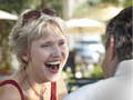 AARP recommends ten cities where older singles can retire well- a woman laughing while sitting in a cafe