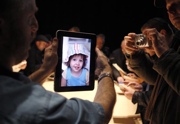 A guest tries out the photo display on a new iPad.