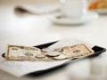 dollar bills and coins on tip tray