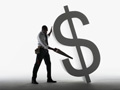 man sawing a dollar sign