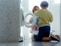 grandmother teaching her grandchild how to do laundry