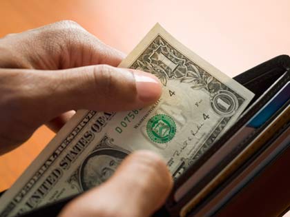 mixed race man taking money out of wallet