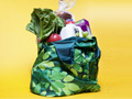 A reusable shopping bag full of groceries 99 ways to save money on shopping 	