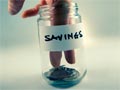 Should I save money or pay off debt?- fingers in the savings jar