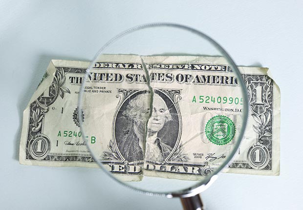 Billete de un dólar con una lupa