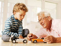 Abuelo jugando con carritos con su nieto