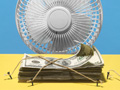 fan blowing a stack of money that is tied down with twine