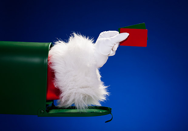 Santa's arm out of a mailbox holding gift card, frugal holiday