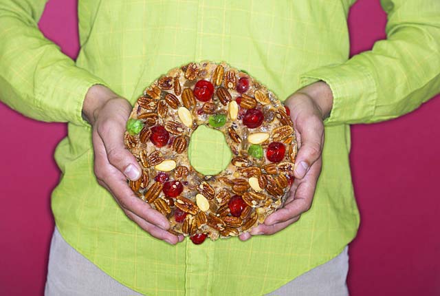 Woman holds a fruitcake against her stomach, frugal holiday