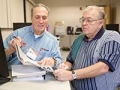 Tax-Aide volunteer Jim Gonzales goes over tax documents with Ray Jimenez