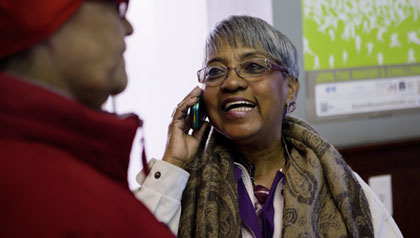 Carmen Pola on phone, AARP Massachusetts Latino community