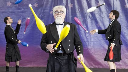 Portrait of Harry Levine, of The Flying Karamozov Brothers, with Steve Horstmann, Jeremy Perkins, and Amiel Martin juggling in the background in Layton, UT