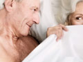 Better sex in the new year- a senior couple flirt in bed