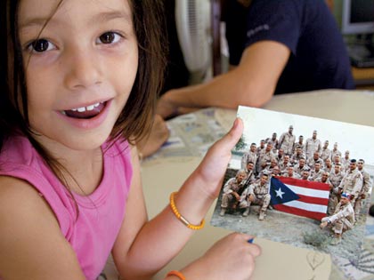 girl holding photo of soldiers in Iraq