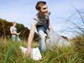 Young adults are more empathic and idealistic than older generations fear- a young man cleans up trash in the outdoors