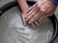 Manos de un abuelo prensa las de su nieto en el cemento para hacer impresiones - 8 Actividades de Ciencia divertidas para hacer con sus nietos