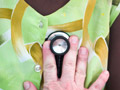doctor's hand with stethoscope with Haitian patient