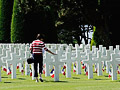 A women touches one of the crosses in the American Military Cemetery near Omaha Beach, Colleville sur Mer in Normandy, France