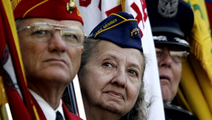 Veterans in uniforms with flags - Veterans Day trivia quiz 