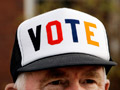 man wearing cap with VOTE on brim