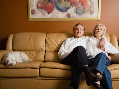 mature couple on sofa with their pet dog mature couple on sofa with their pet dog