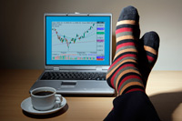 feet up on a desk with coffee cup and laptop