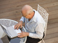 senior man working on laptop in social age