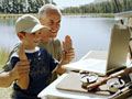 Older father and son on web camera on fishing trip for Internet on the Go