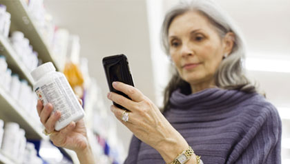 five ways to save money with smartphone mature woman shopping in store with smartphone